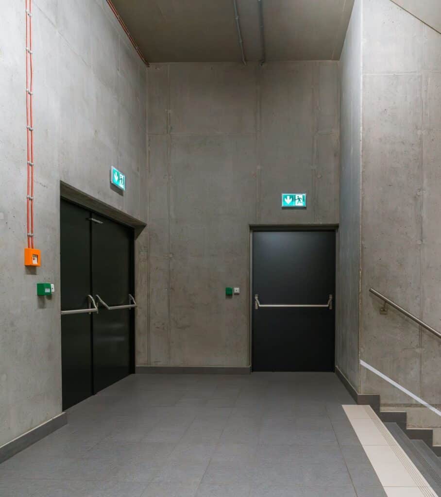 Modern indoor stairway with emergency exit doors in an industrial building.