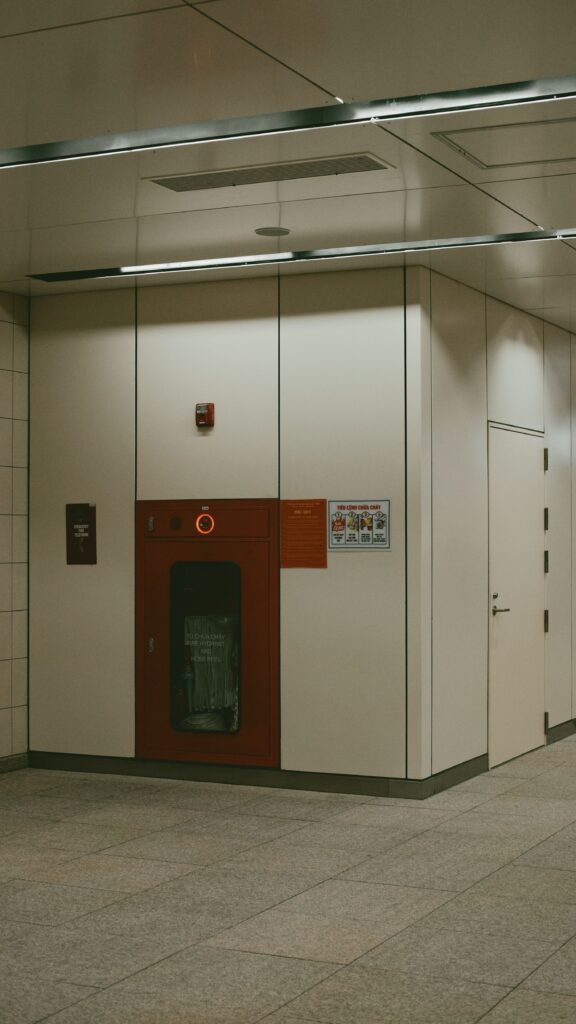 A contemporary indoor corner with fire safety equipment in a subway or public area.